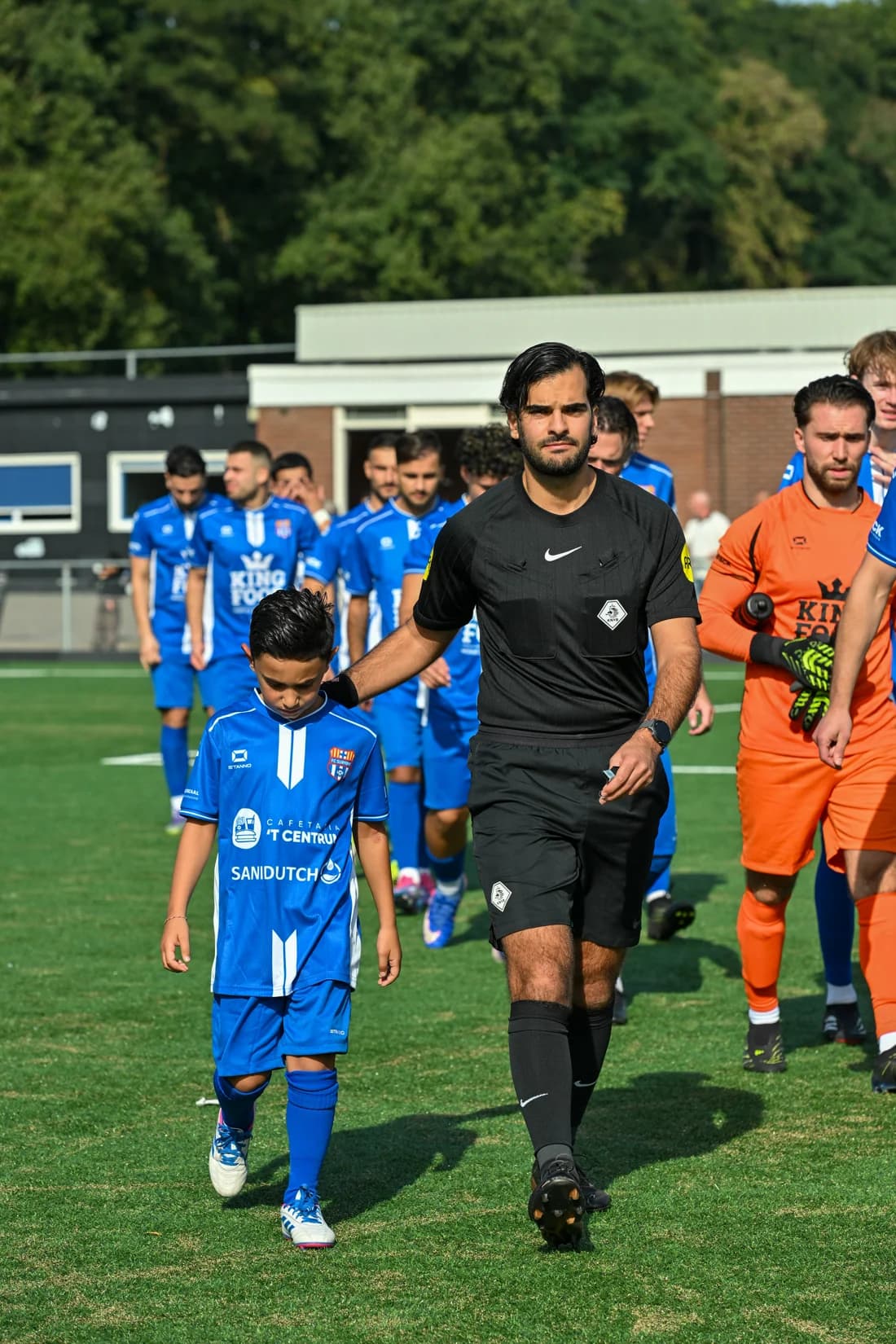 Jeugdleden en spelers lopen het veld op